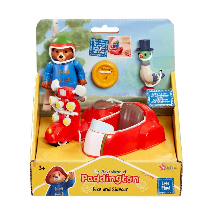 Paddington 'The Adventures of' toy set 'Bike and Sidecar' in its original retail packaging. The set includes a red and white sidecar, a red and white bike, a Paddington bear figure in a blue duffel coat, and a white pigeon figure wearing a top hat.