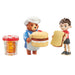 Toy figure playset of Paddington bear in a chef's outfit holding a cake, a boy holding a sandwich, and a jar with a red lid on a white background.