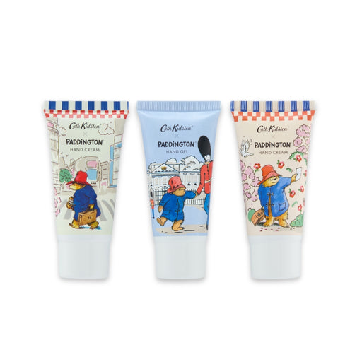 Three tubes of Cat Kidston Paddington hand creams and gel arranged side by side on a white background, featuring illustrations of Paddington Bear in different scenes.