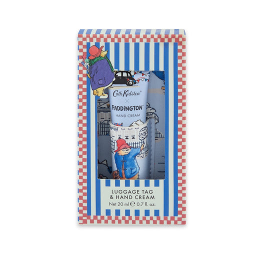 A boxed set of a Cath Kidston Paddington hand cream and luggage tag  in a blue-and-white striped and red gingham package with Paddington illustrations.