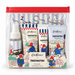 Cath Kidston x Paddington Travel Essentials gift set in a clear zip pouch with a red zipper. The set includes a hand gel bottle, lip balm, hand cream, and a hand gel tube, all decorated with Paddington illustrations and a central label reading 'Cath Kidston x PADDINGTON TRAVEL ESSENTIALS'.