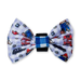 A small fabric bow tie featuring a light blue and white patterned design with paddington bear cartoon characters and london taxis, secured with a blue and white checkered center band and a black elastic closure.