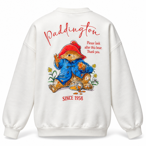 White crewneck sweatshirt shown from the back, featuring a large graphic of Paddington Bear with red text reading 'Paddington' and 'SINCE 1958' on a clean white background.