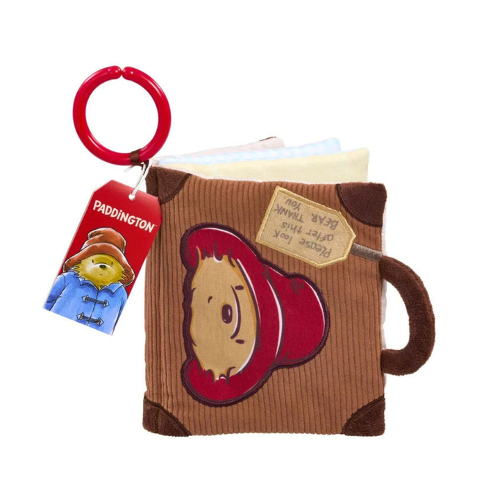 Paddington-themed corduroy book or pouch in brown with a red hat motif, a red key ring, and a red hanging tag featuring Paddington, on a white background.