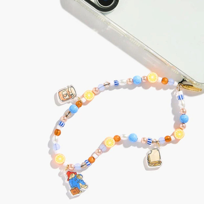 A colorful beaded phone strap with paddington bear character charms, shown attached to a clear smartphone case on a white background.