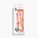 A beaded phone strap by Skinny Dip, featuring colorful round beads in blue, yellow, orange, and white, with small paddington bear charms, shown in its original pink packaging against a white background.