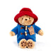 Stuffed toy Paddington bear in a blue coat and red hat on a white background