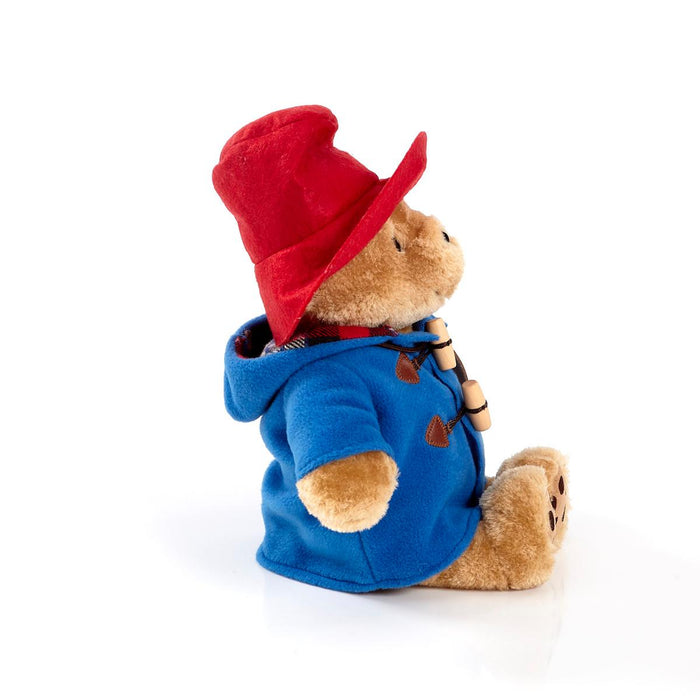 Paddington Teddy bear wearing a blue hoodie and red cap on a white background