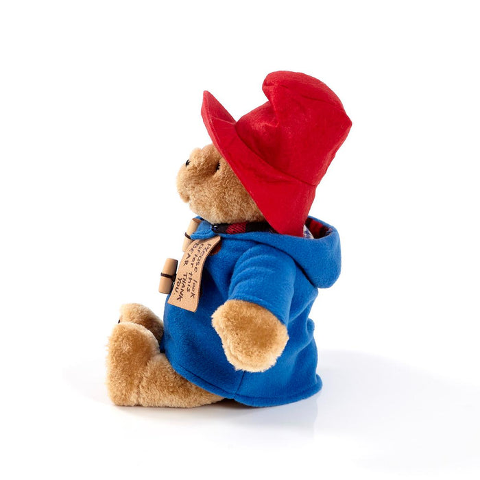 Paddington Plush toy bear wearing a red hat and blue coat on a white background