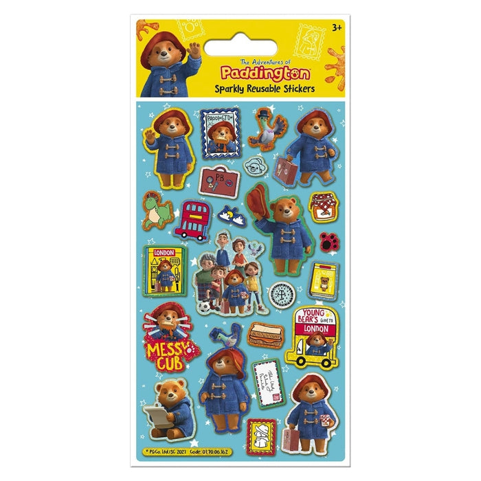 A package of Paddington-themed reusable stickers on a light blue backing card. The stickers feature multiple illustrations of Paddington Bear in his blue coat, along with London scenes, a red double-decker bus, a yellow cab, and other Paddington-related items.