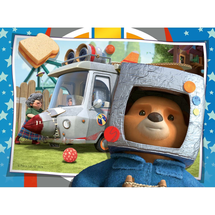 paddington bear in a space helmet with a vehicle and people in the background