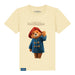 A butter cream kids' T-shirt with a graphic of Paddington Bear in a red hat and blue coat on a yellow background, with the text 'The Adventures of Paddington'.