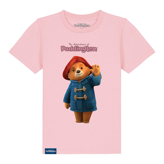 A pink kids' T-shirt with a graphic of Paddington Bear in a red hat and blue coat on a pink background, with the text 'The Adventures of Paddington'.