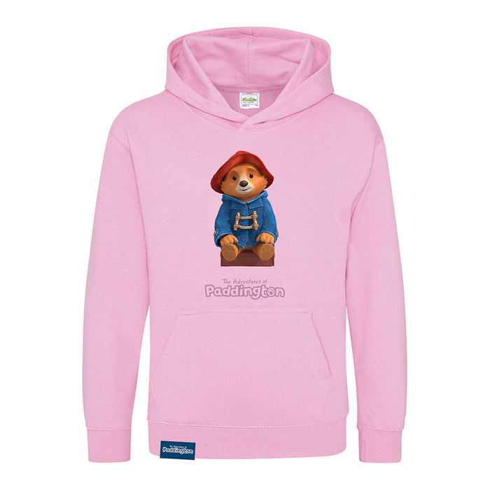 A pink kids hoodie with a graphic of Paddington bear wearing a blue jacket and a red hat.
