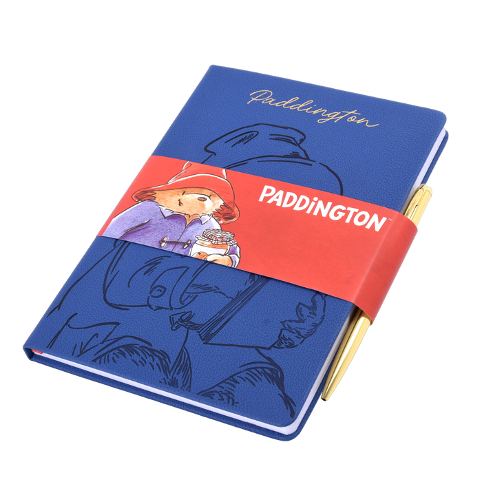 Blue notebook and golden pen with Paddington Bear design on a white background