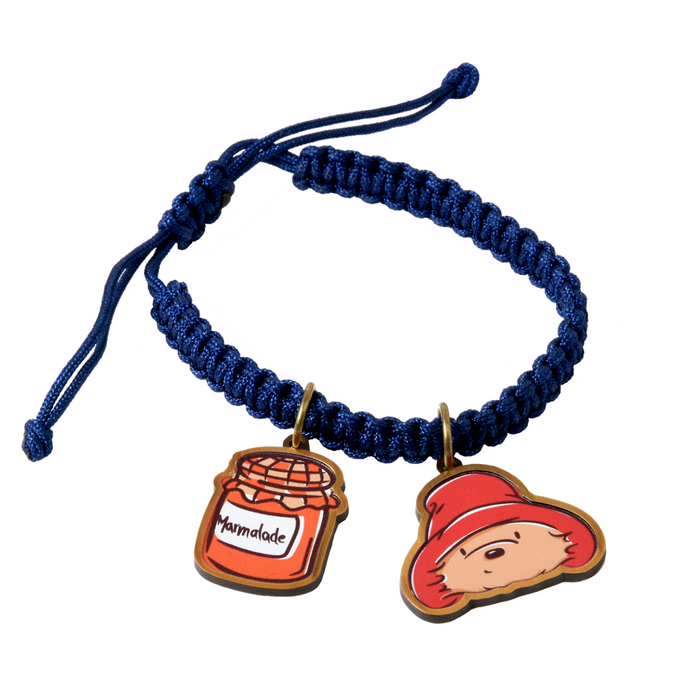 Navy blue braided Paddington bear bracelet with two charms on a white background