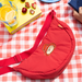 Red crossbody bag with a cartoon paddington bear character on a red and white checkered tablecloth.