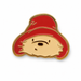 A cartoon-style enamel pin of a Paddington bears face wearing a red hat, outlined in gold brass metal, on a plain white background.
