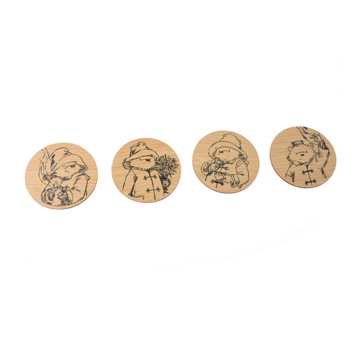 Four wooden Paddington coasters with engraved sketch illustrations of Paddington bear himself, on a white background.