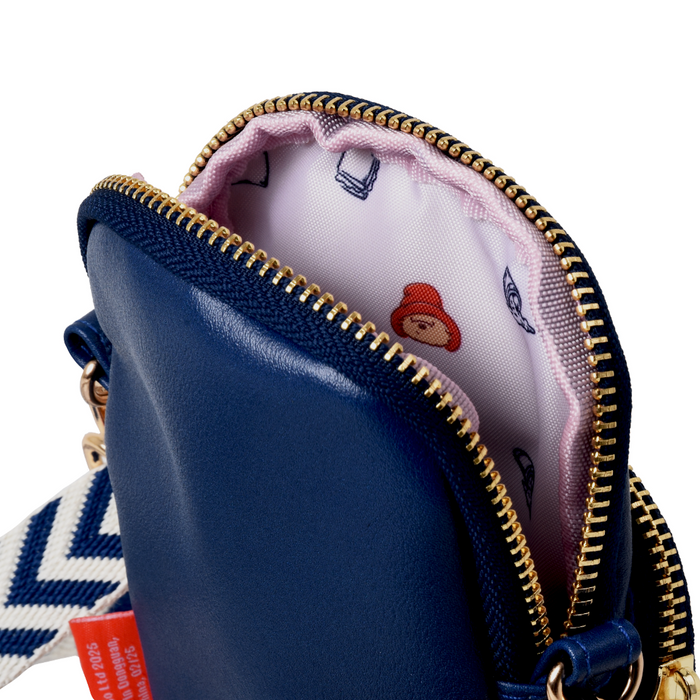 Close-up of a blue pouch with gold zipper, white interior, and visible Paddington brand logo.