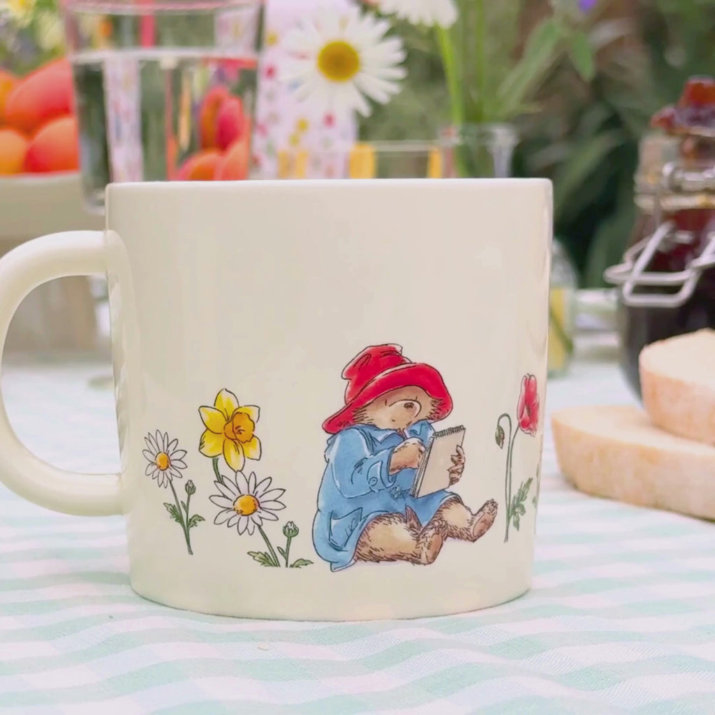 Video of a summer tablescape featuring a paddington floral mug and someone sipping from the cup on top of the tableware