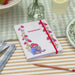 Video of a summer tablescape featuring a paddington A5 notebook and two girls smiling whilst reading amongst the flowers
