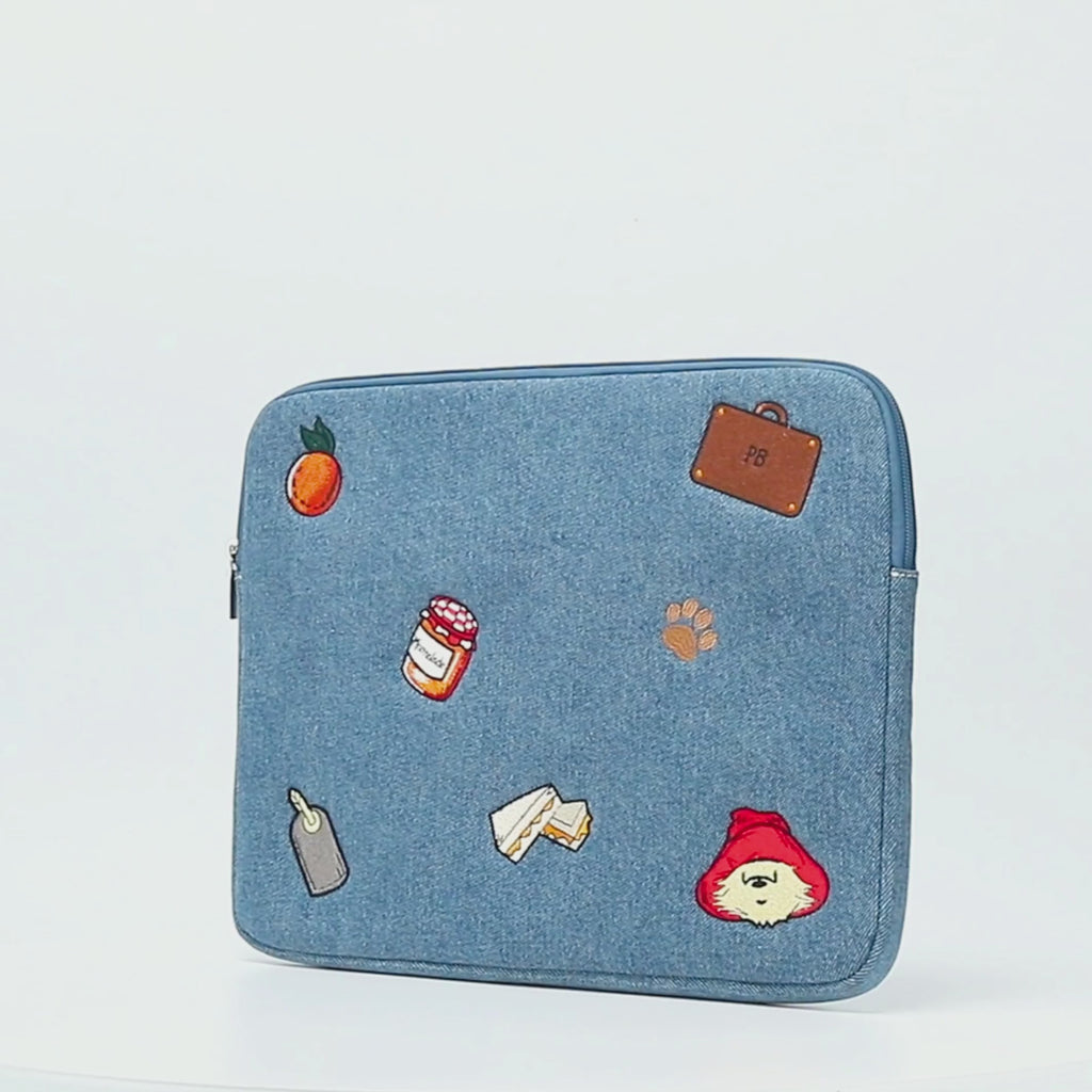 Paddington P.B. Collection blue denim laptop case with zip fastening and Paddington detailing shown in close-up.