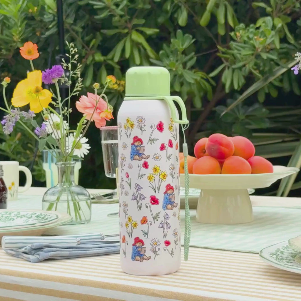 Video of a summer tablescape featuring a floral thermos water bottle and a girl drinking water from an open screw top bottle in hand